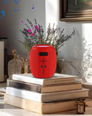 Altavoz inalámbrico BASE rojo con correa portátil, perfecto para audio en exteriores.