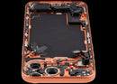 Tapa trasera usada Cosmic Orange para iPhone 17 Pro Max con puerto de carga y pequeñas piezas.